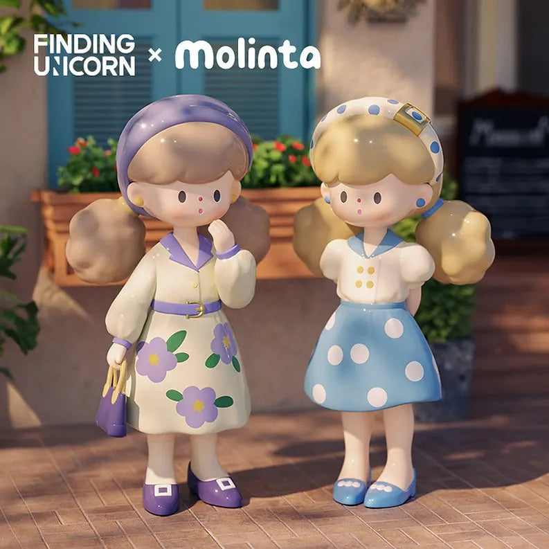 Two Molinta Retro Girls vinyl figures, one in a purple flower dress with matching headband, and the other in a blue polka-dot skirt and headband.
