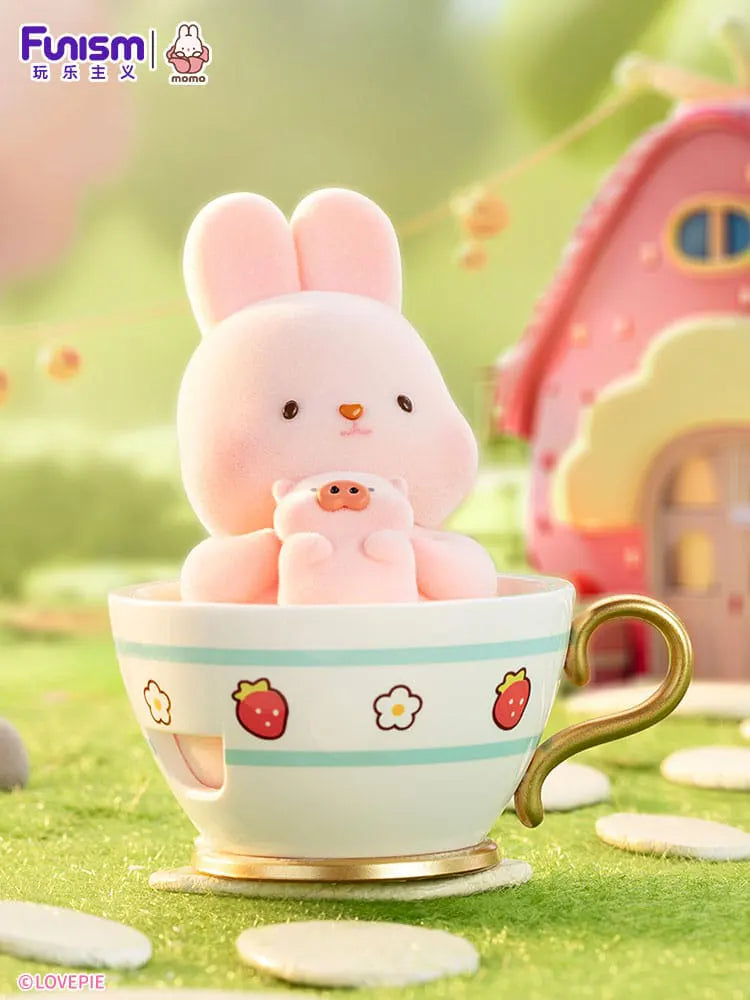 Momo Bunny Strawberry Town figure inside teacup holding plush toy.