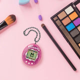 Tamagotchi Pink Glitter device placed on makeup desk setup.