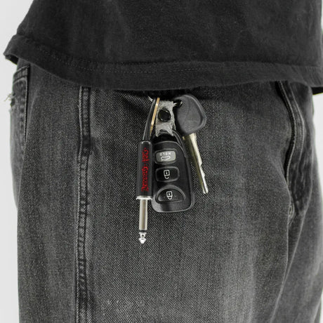 Ozzy Osbourne guitar plug keychain attached to keys in pocket