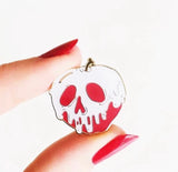 Spooky fairytale-inspired apple pin with white skull drip detailing