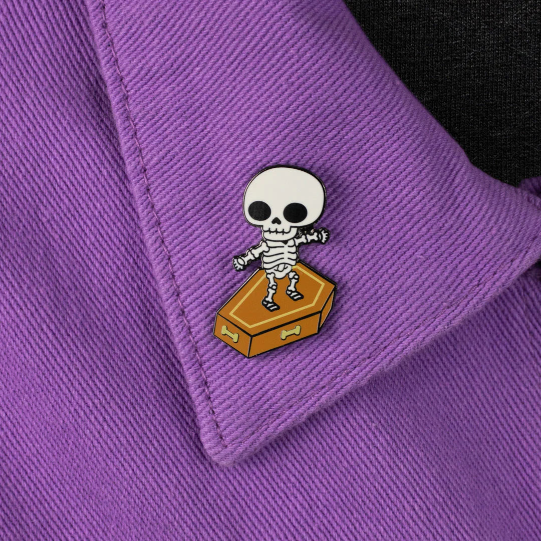 Skull Surfer hard enamel pin worn on purple jacket fabric
