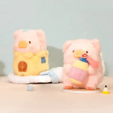 LuLu The Piggy plush holding a colorful cupcake beside a miniature plush house