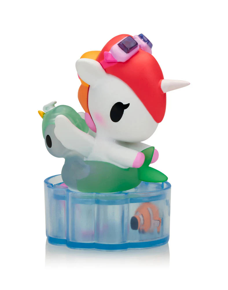 Fun in the Sun Unicorno figure floating in pool with green floatie and goggles