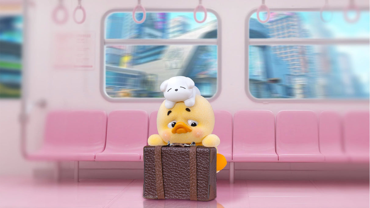 Upset Duck travel mood vinyl figure sitting on pink subway seat with suitcase