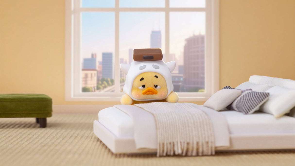 Upset Duck bed mood vinyl figure resting on modern white bed display