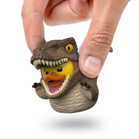 Close-up of Velociraptor Mini TUBBZ being held between fingers