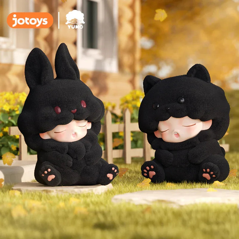 Black bunny and black bear Yumo flocked figures sitting outdoors.