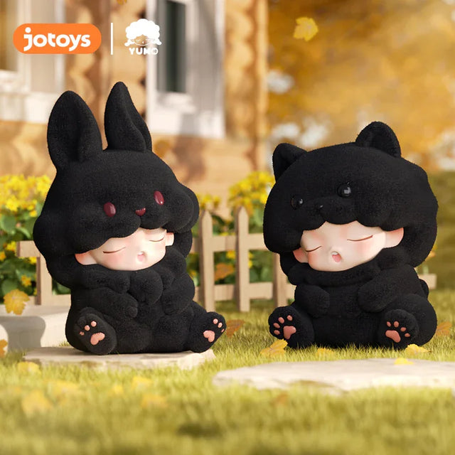 Black bunny and black bear Yumo flocked figures sitting outdoors.